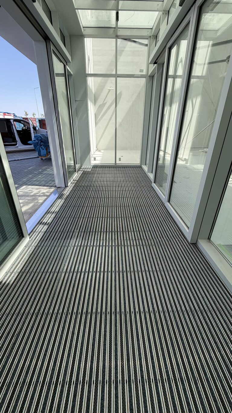 Długi ciąg wycieraczki aluminiowej w przeszklonym wiatrołapie