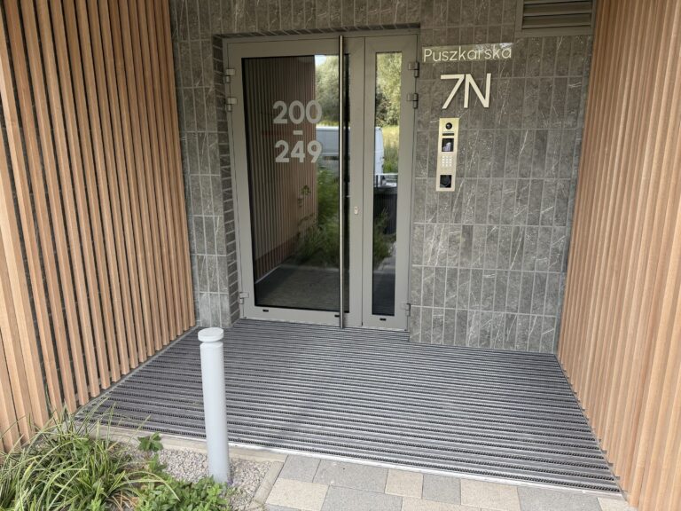 Wycieraczka aluminiowa w strefie wejściowej z drewnianą okładziną