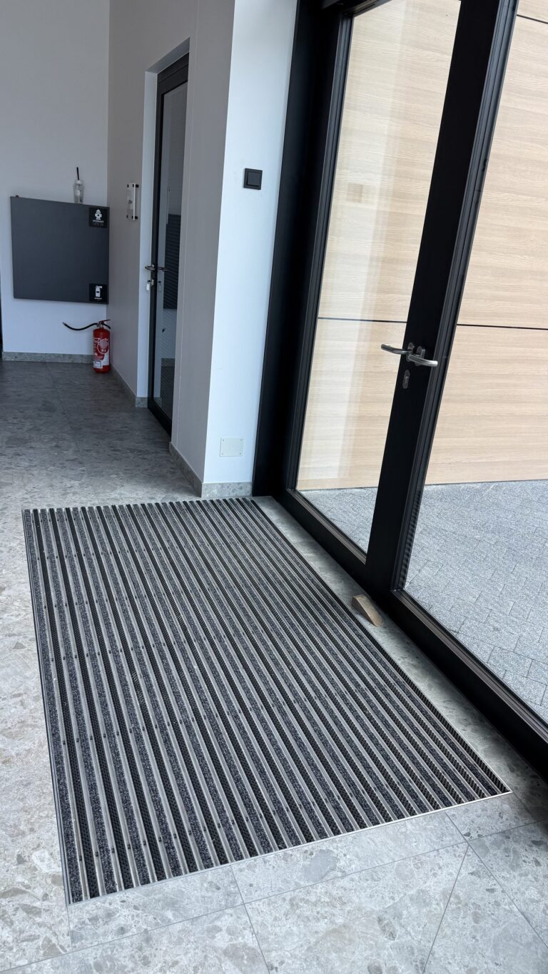 Wycieraczka aluminiowa w holu przy drzwiach wejściowych