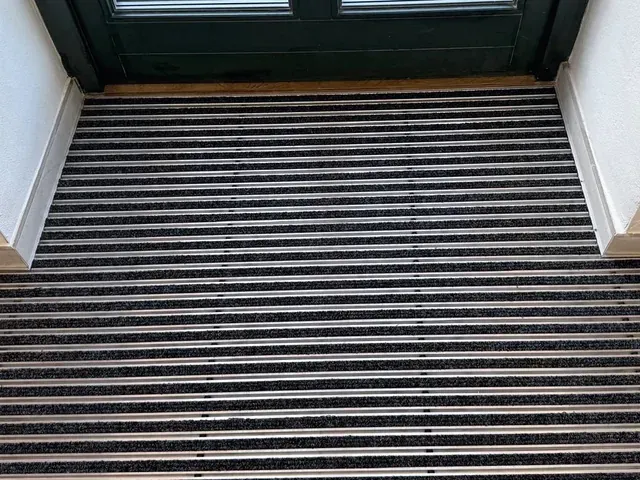 Aluminiowa mata wejściowa NEVRA zamontowana w ościeżnicy drzwi